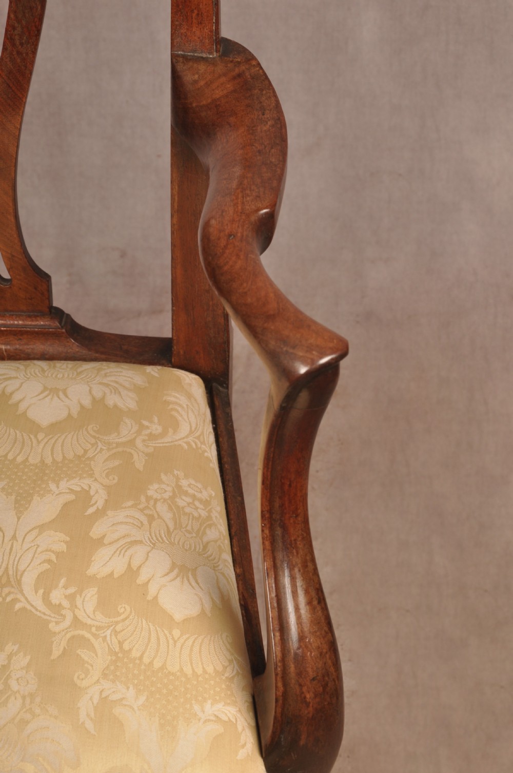 A George II mahogany armchair featuring a pierced back splat, swept armrests, a cream fabric seat, and cabriole front legs. View VI