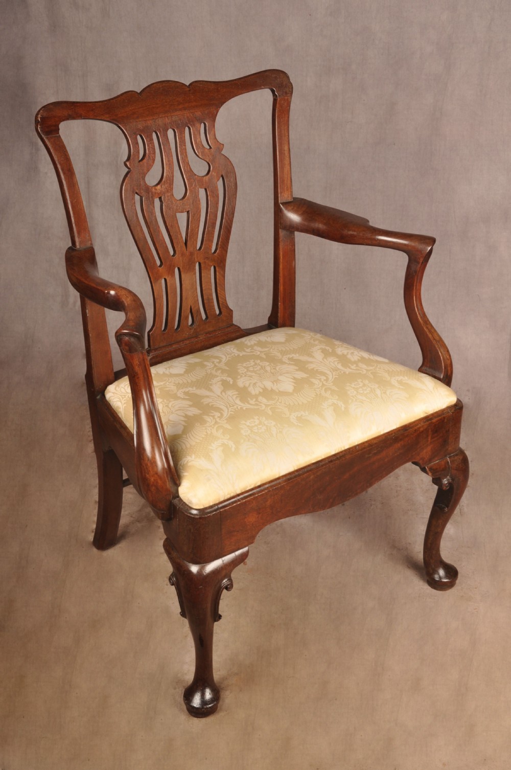 A George II mahogany armchair featuring a pierced back splat, swept armrests, a cream fabric seat, and cabriole front legs. View VIII