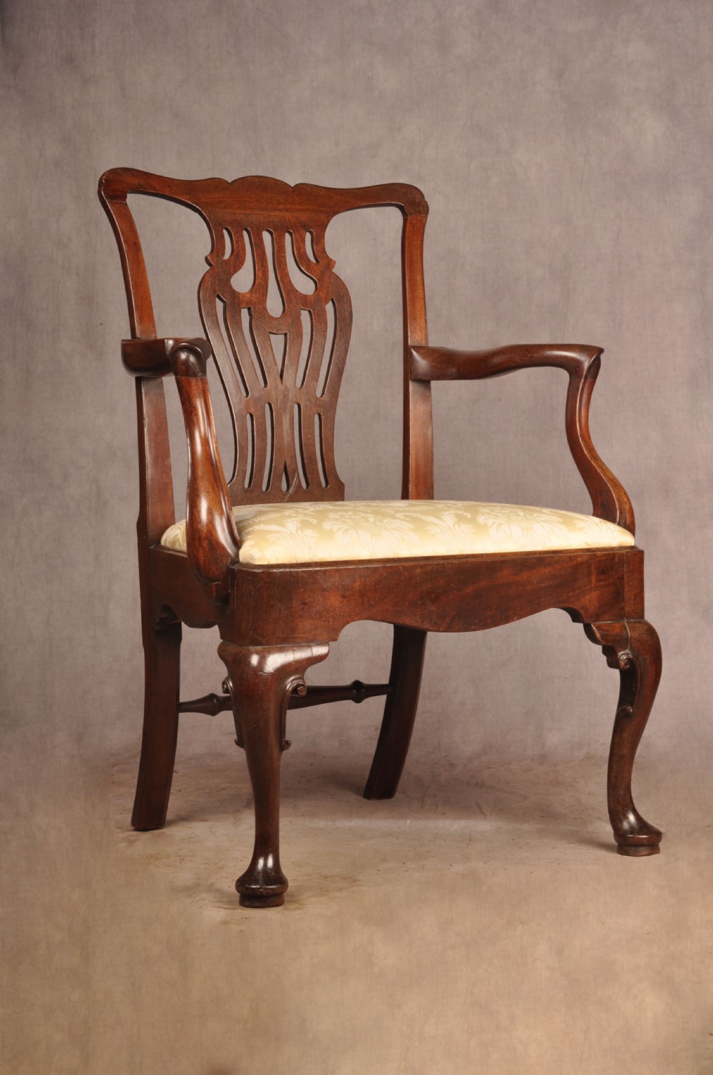 A George II mahogany armchair featuring a pierced back splat, swept armrests, a cream fabric seat, and cabriole front legs. View IX