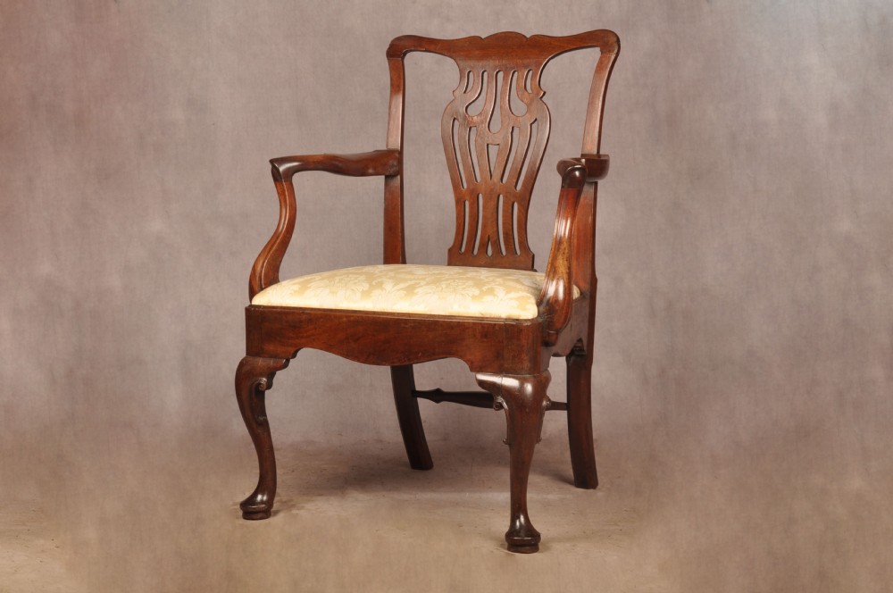 A George II mahogany armchair featuring a pierced back splat, swept armrests, a cream fabric seat, and cabriole front legs. View II