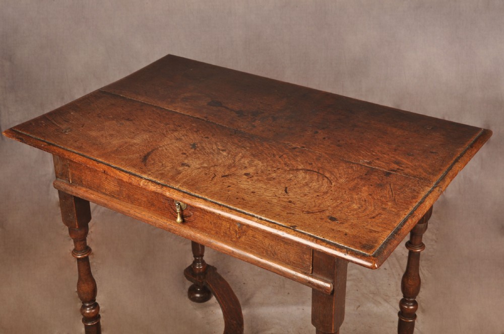 A 17th-century oak side table featuring baluster-turned legs, a shaped X-stretcher, a single frieze drawer with a brass drop handle, and a rectangular timber top. View II
