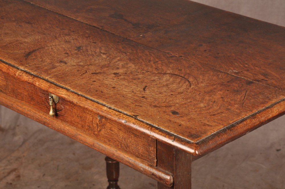 A 17th-century oak side table featuring baluster-turned legs, a shaped X-stretcher, a single frieze drawer with a brass drop handle, and a rectangular timber top. View III