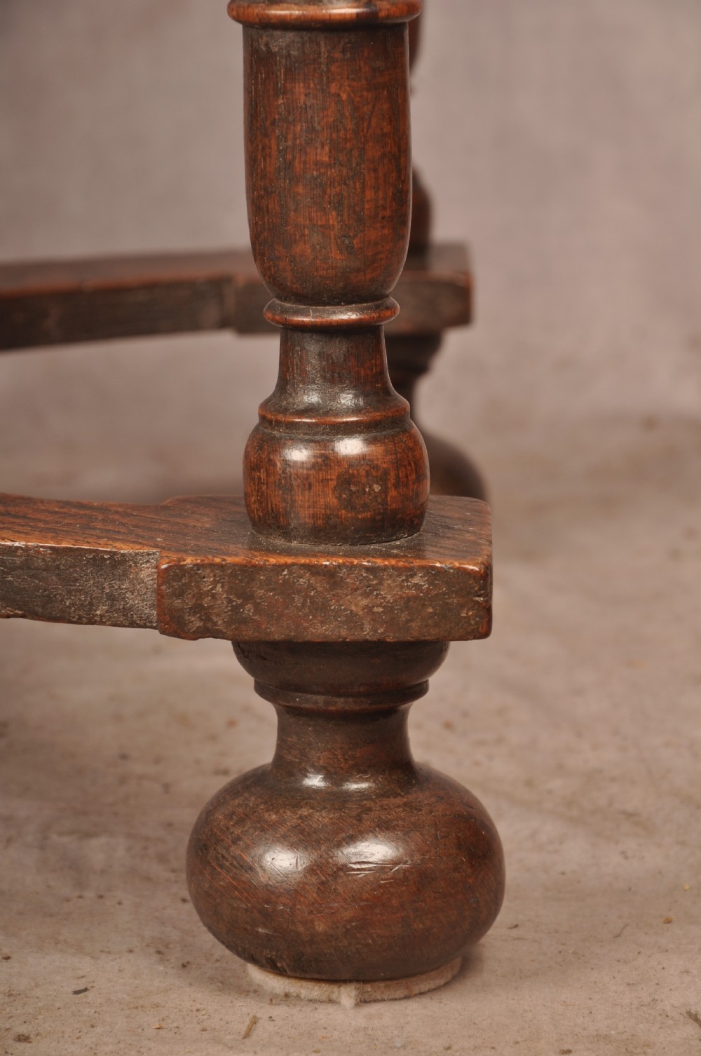 A 17th-century oak side table featuring baluster-turned legs, a shaped X-stretcher, a single frieze drawer with a brass drop handle, and a rectangular timber top. View VII
