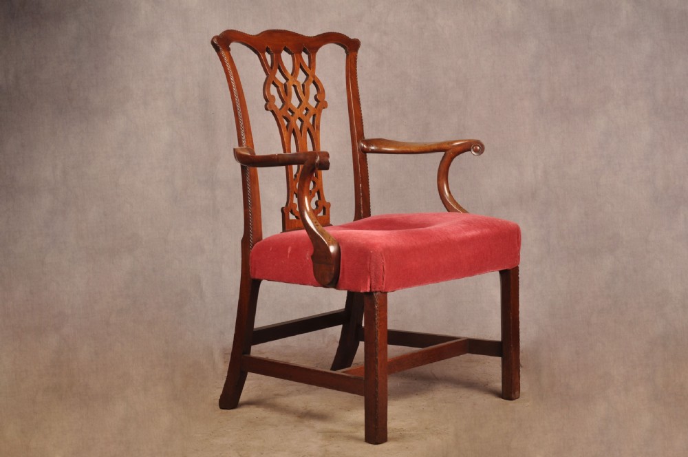 An 18th-century Chippendale style mahogany armchair featuring a pierced lattice splat back, curved arms, square legs with stretchers, and a red upholstered seat. View II