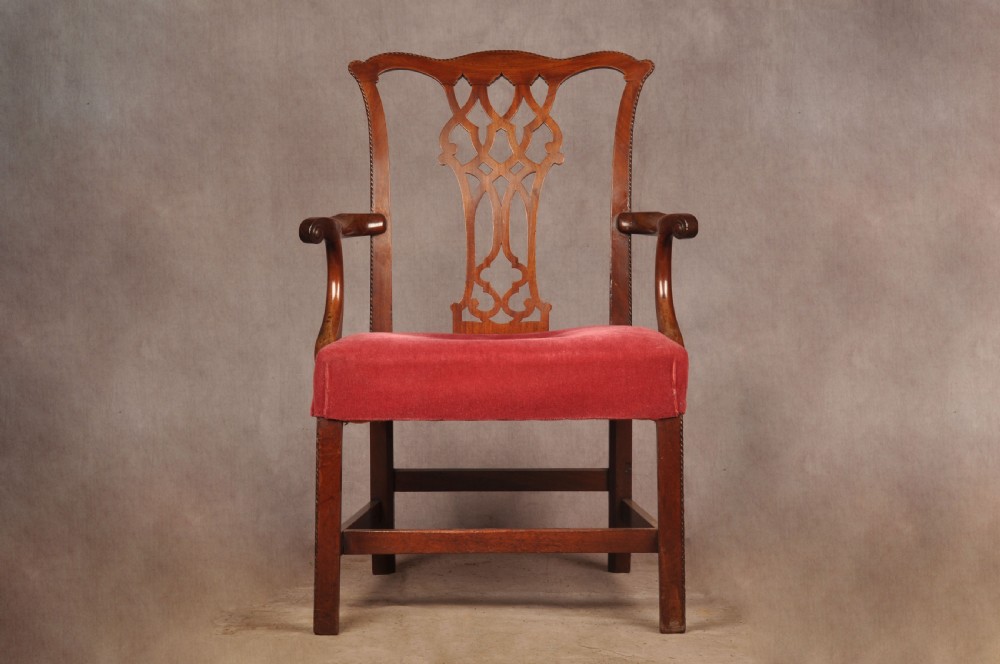 An 18th-century Chippendale style mahogany armchair featuring a pierced lattice splat back, curved arms, square legs with stretchers, and a red upholstered seat. View III