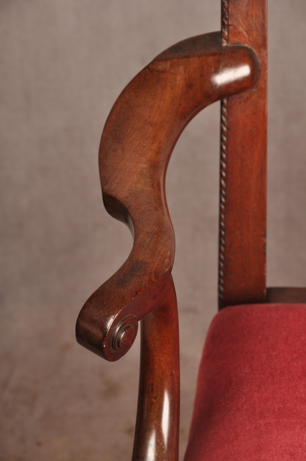 An 18th-century Chippendale style mahogany armchair featuring a pierced lattice splat back, curved arms, square legs with stretchers, and a red upholstered seat. View VIII