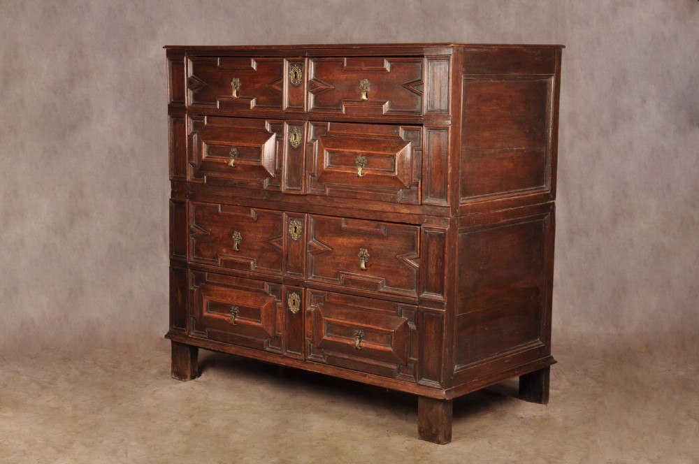 A 17th-century Charles II walnut and fruitwood chest of drawers featuring geometric mitred panels and brass keyhole escutcheons. View III