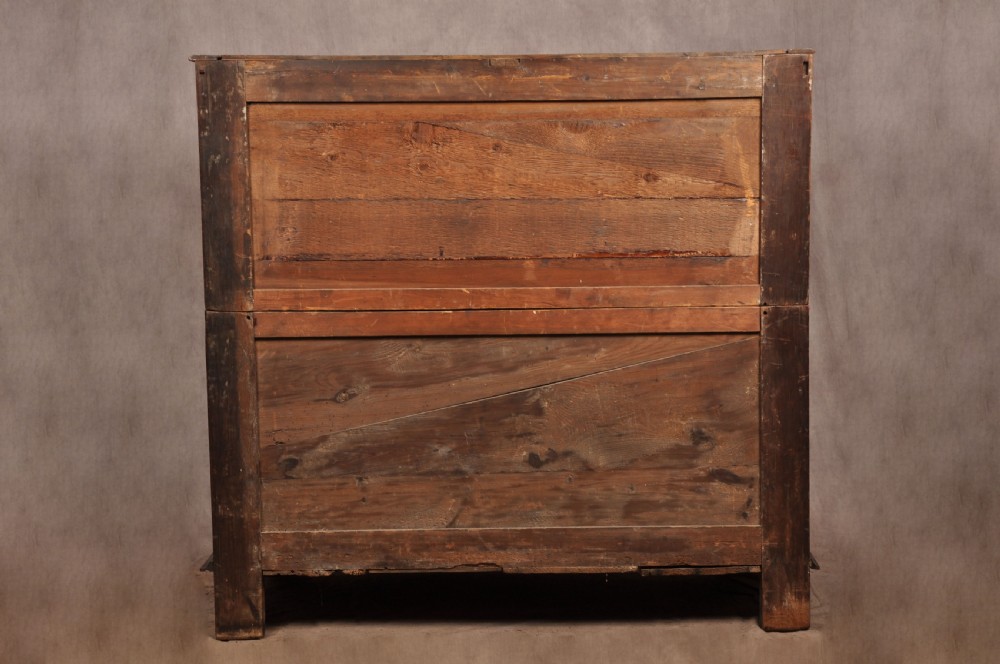 A 17th-century Charles II walnut and fruitwood chest of drawers featuring geometric mitred panels and brass keyhole escutcheons. View XIX