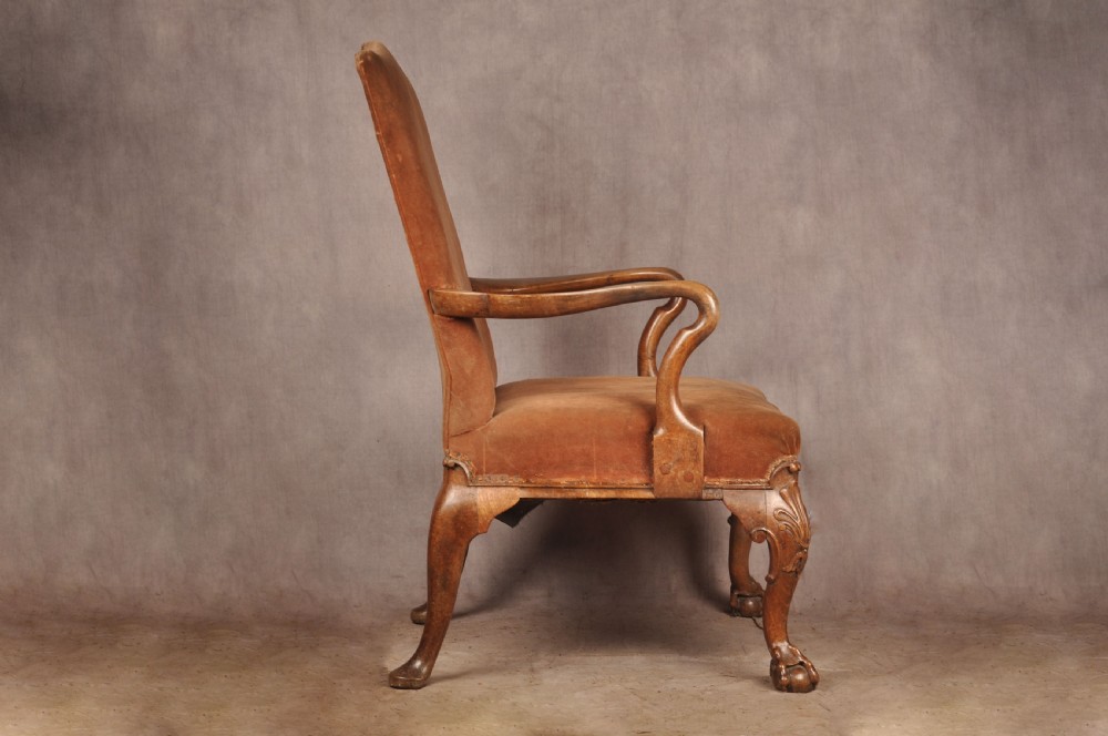 A 19th-century walnut library armchair upholstered in terracotta velvet with carved cabriole legs and claw and ball feet. View II