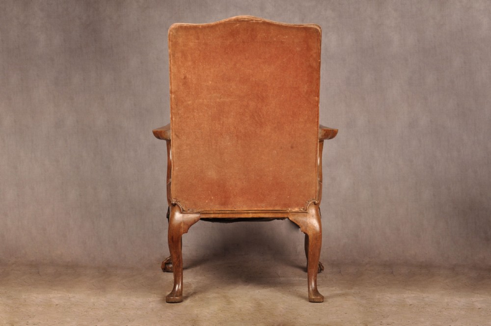 A 19th-century walnut library armchair upholstered in terracotta velvet with carved cabriole legs and claw and ball feet. View VII