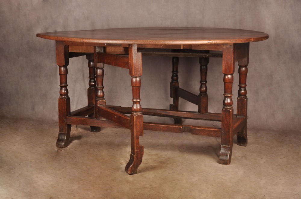 An 18th-century oak gateleg dining table with folded drop leaves, turned legs, and square stretchers. View IV