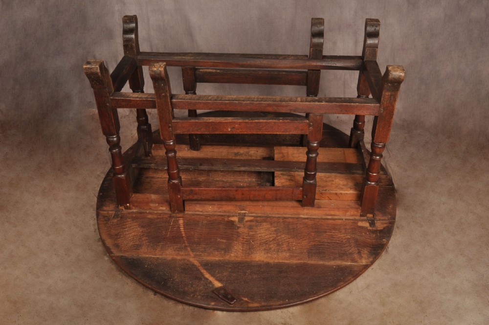 An 18th-century oak gateleg dining table with folded drop leaves, turned legs, and square stretchers. View VII