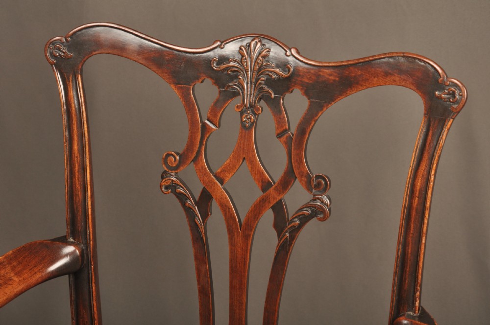 An 18th-century Chippendale mahogany armchair featuring a carved pierced splat back, swept armrests, an upholstered drop-in seat, and square legs joined by H-stretchers. View IV