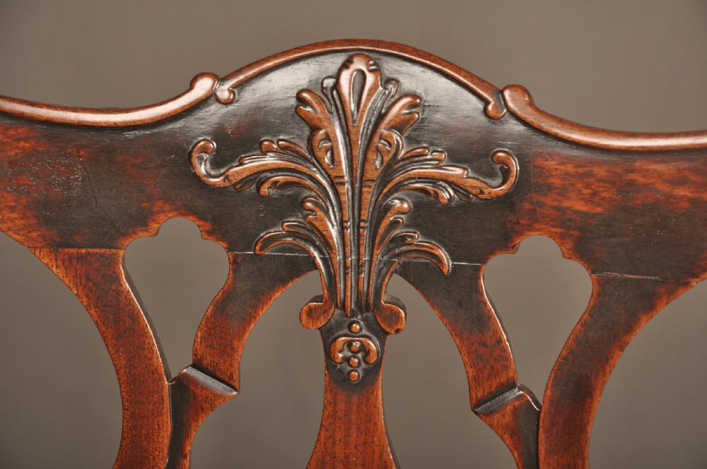 An 18th-century Chippendale mahogany armchair featuring a carved pierced splat back, swept armrests, an upholstered drop-in seat, and square legs joined by H-stretchers. View VI