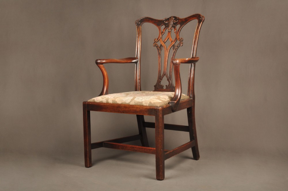 An 18th-century Chippendale mahogany armchair featuring a carved pierced splat back, swept armrests, an upholstered drop-in seat, and square legs joined by H-stretchers. View IX