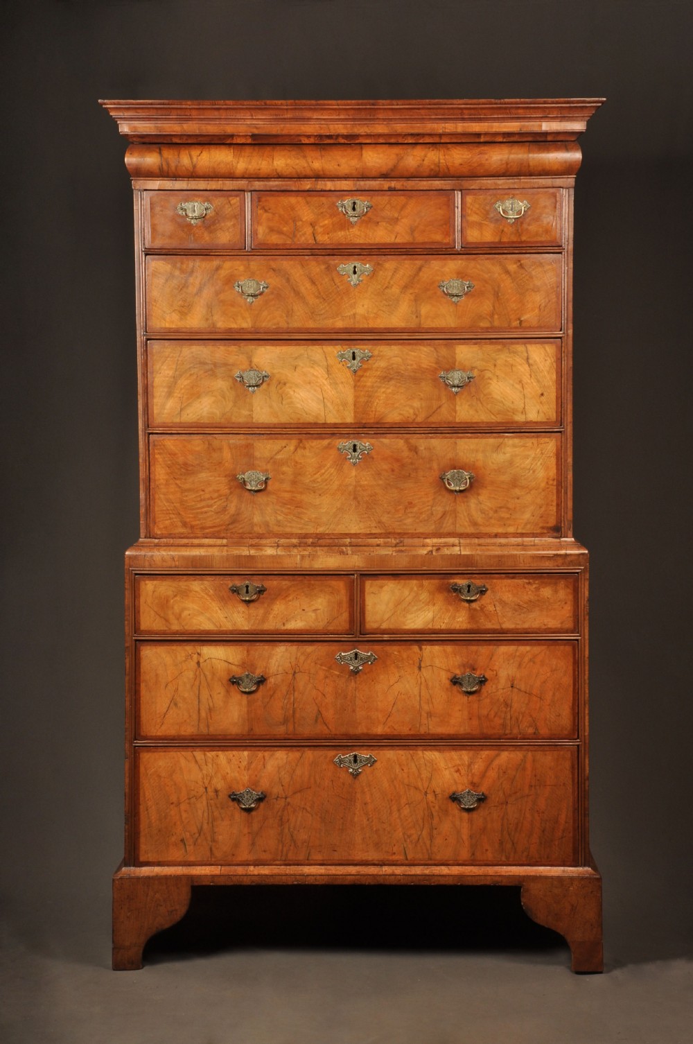 A tall Queen Anne walnut chest on chest featuring two stacked sections of drawers with brass handles and bracket feet. View II