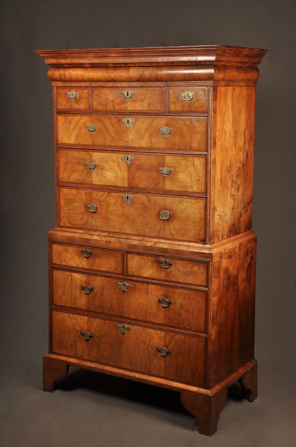 A tall Queen Anne walnut chest on chest featuring two stacked sections of drawers with brass handles and bracket feet. View III