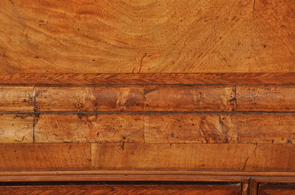 A tall Queen Anne walnut chest on chest featuring two stacked sections of drawers with brass handles and bracket feet. View VI
