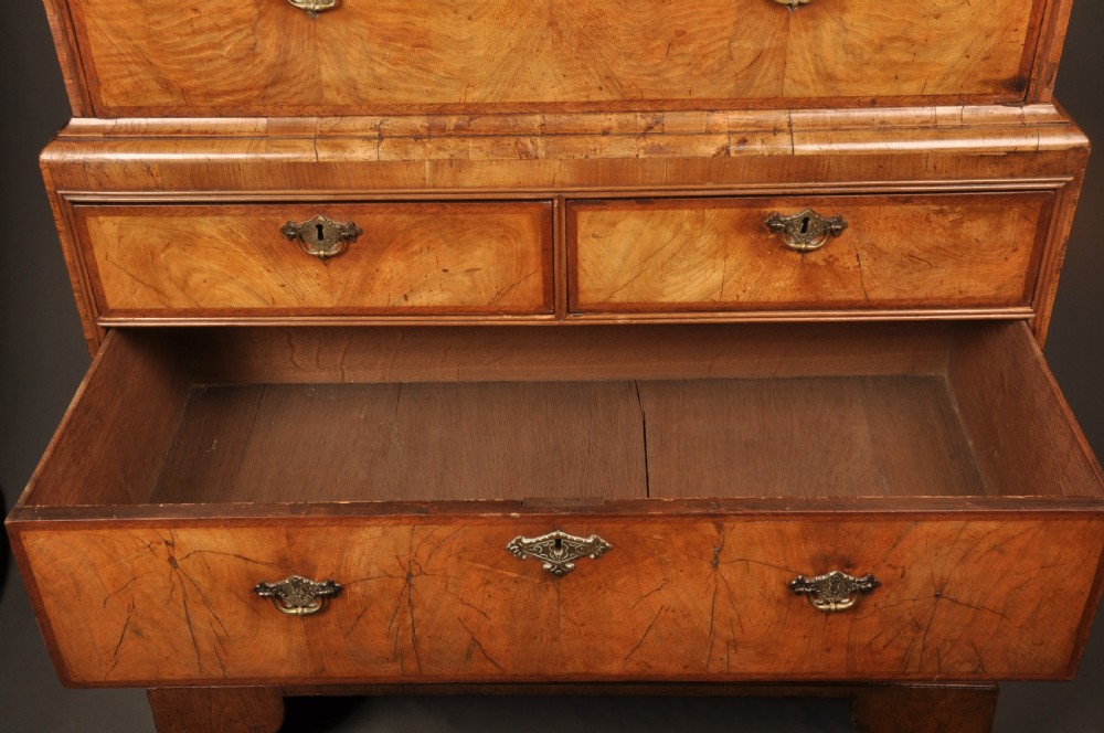 A tall Queen Anne walnut chest on chest featuring two stacked sections of drawers with brass handles and bracket feet. View VIII