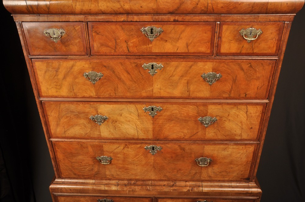 A tall Queen Anne walnut chest on chest featuring two stacked sections of drawers with brass handles and bracket feet. View XII