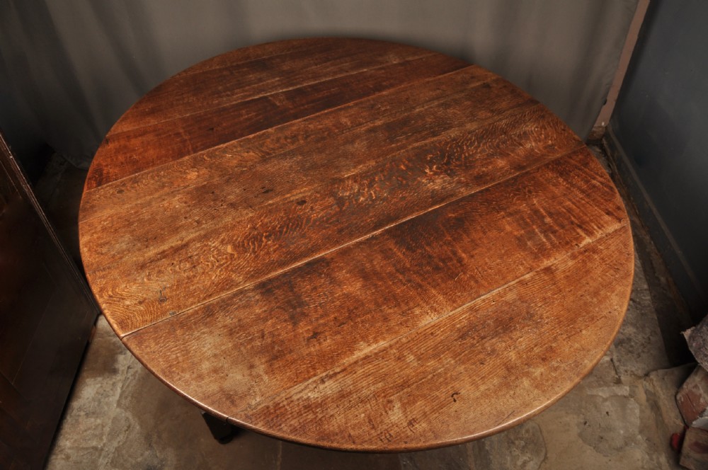 A large 17th-century solid oak gateleg dining table featuring drop leaves, turned legs, and perimeter stretchers. View VI