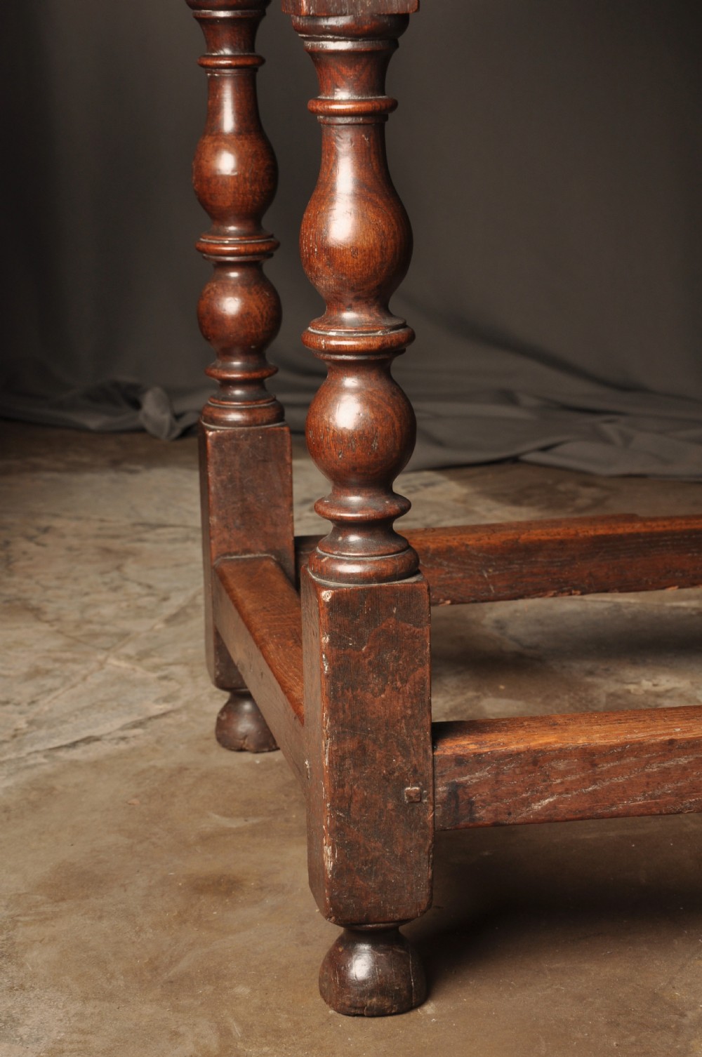 A large 17th-century solid oak gateleg dining table featuring drop leaves, turned legs, and perimeter stretchers. View VII