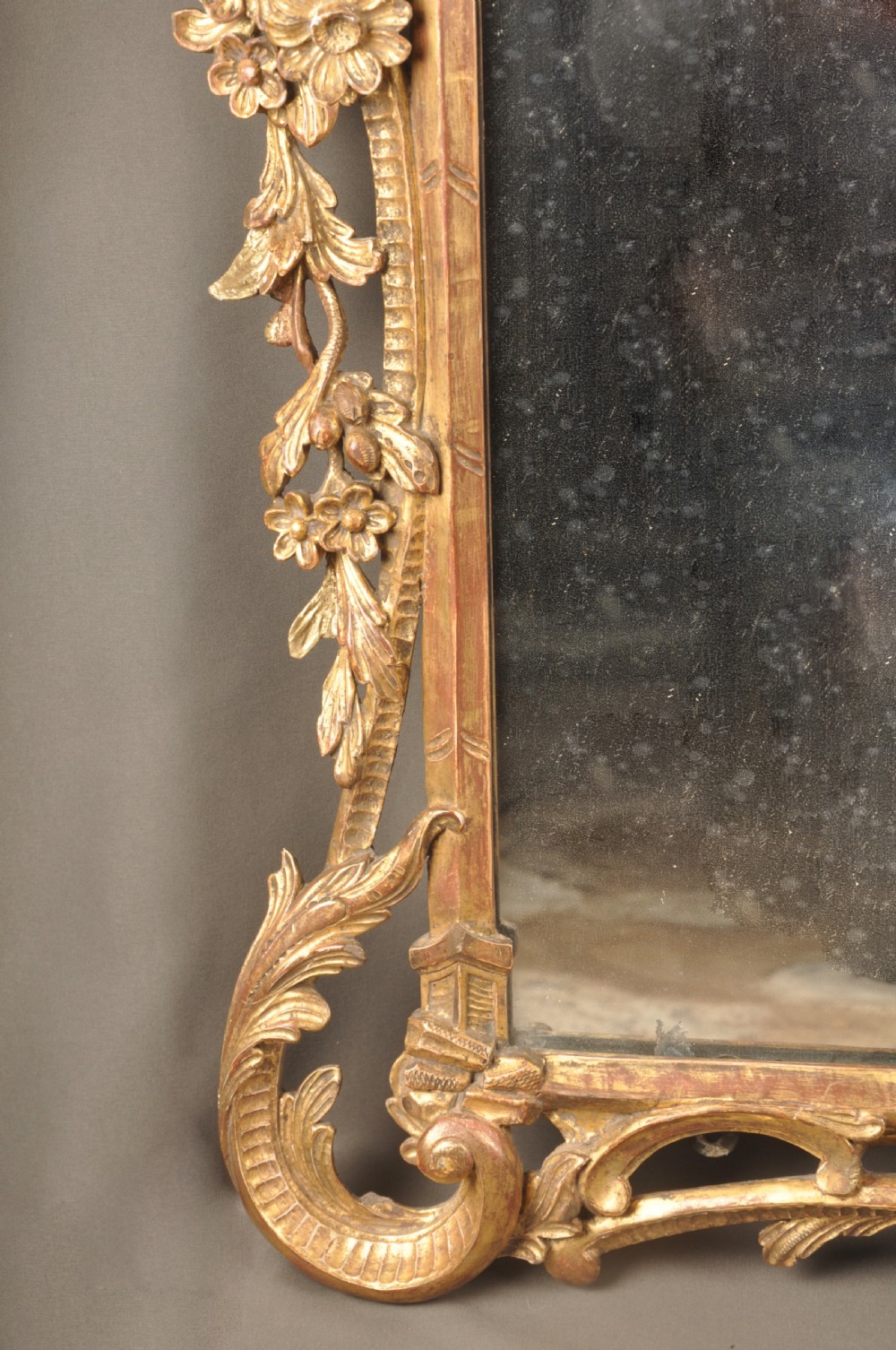 An 18th-century horizontal giltwood overmantel mirror featuring three glass plates set within a carved frame decorated with acanthus scrolls, C-scrolls, and floral motifs. View VII