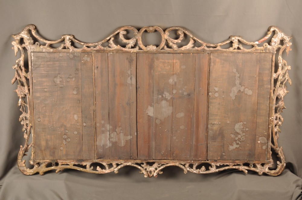 An 18th-century horizontal giltwood overmantel mirror featuring three glass plates set within a carved frame decorated with acanthus scrolls, C-scrolls, and floral motifs. View X