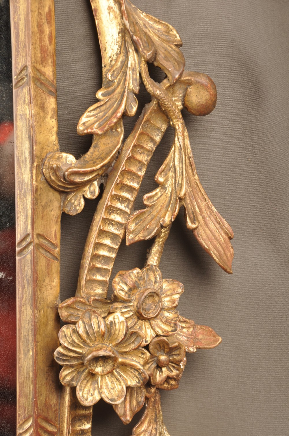 An 18th-century horizontal giltwood overmantel mirror featuring three glass plates set within a carved frame decorated with acanthus scrolls, C-scrolls, and floral motifs. View XI