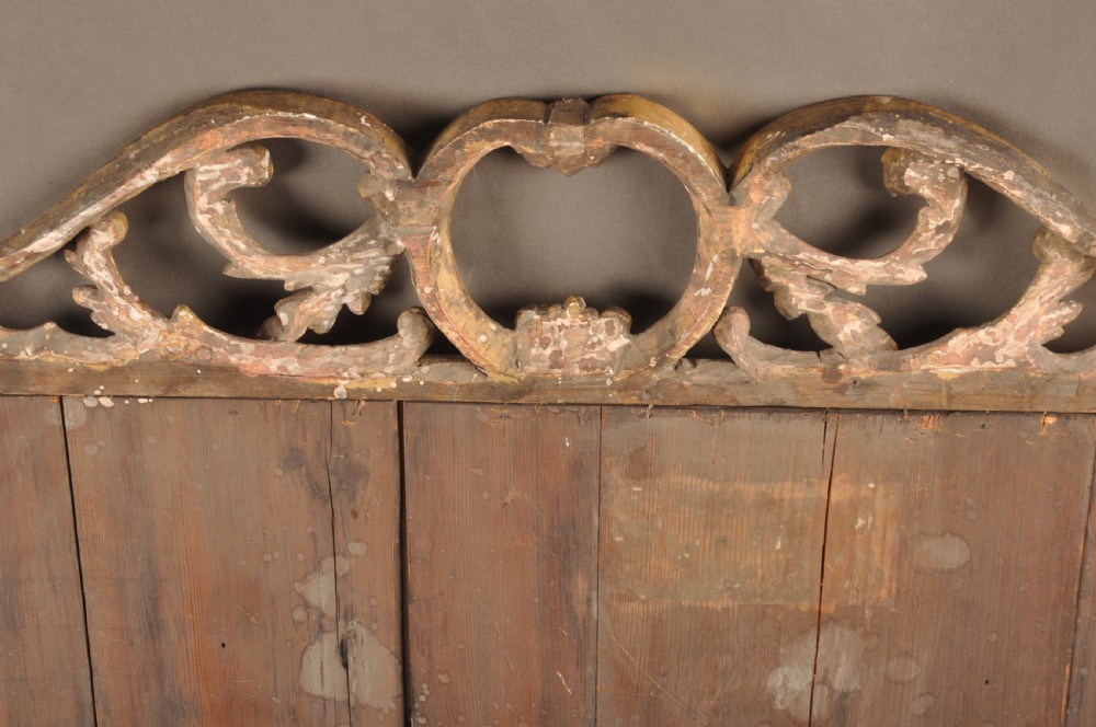 An 18th-century horizontal giltwood overmantel mirror featuring three glass plates set within a carved frame decorated with acanthus scrolls, C-scrolls, and floral motifs. View XII