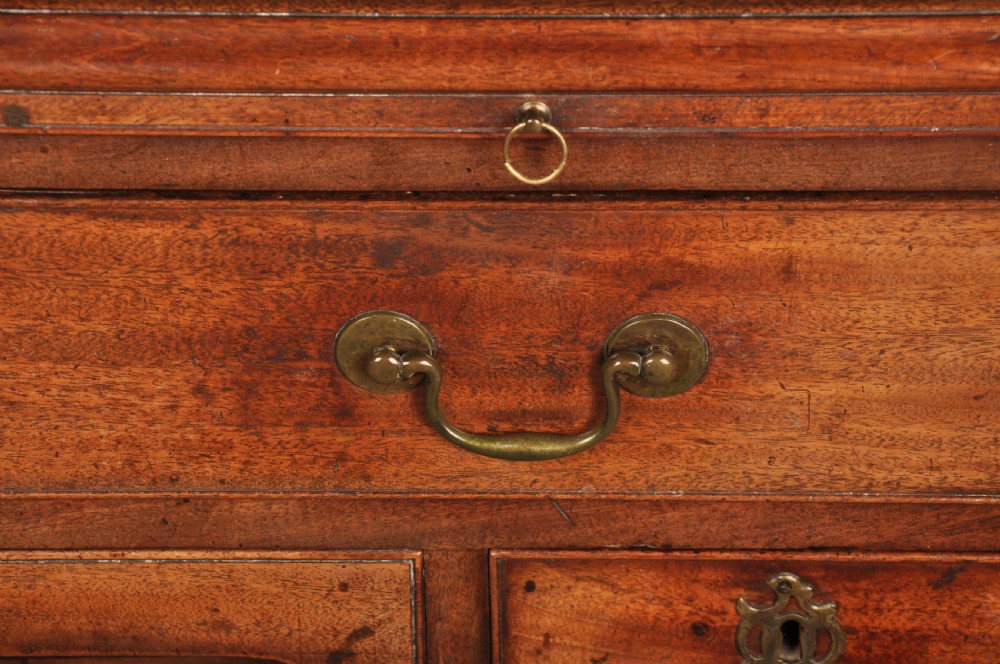 An 18th-century mahogany kneehole desk featuring a long upper drawer, six smaller side drawers, a central recessed cupboard, and bracket feet. View II