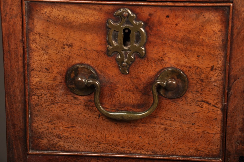 An 18th-century mahogany kneehole desk featuring a long upper drawer, six smaller side drawers, a central recessed cupboard, and bracket feet. View III