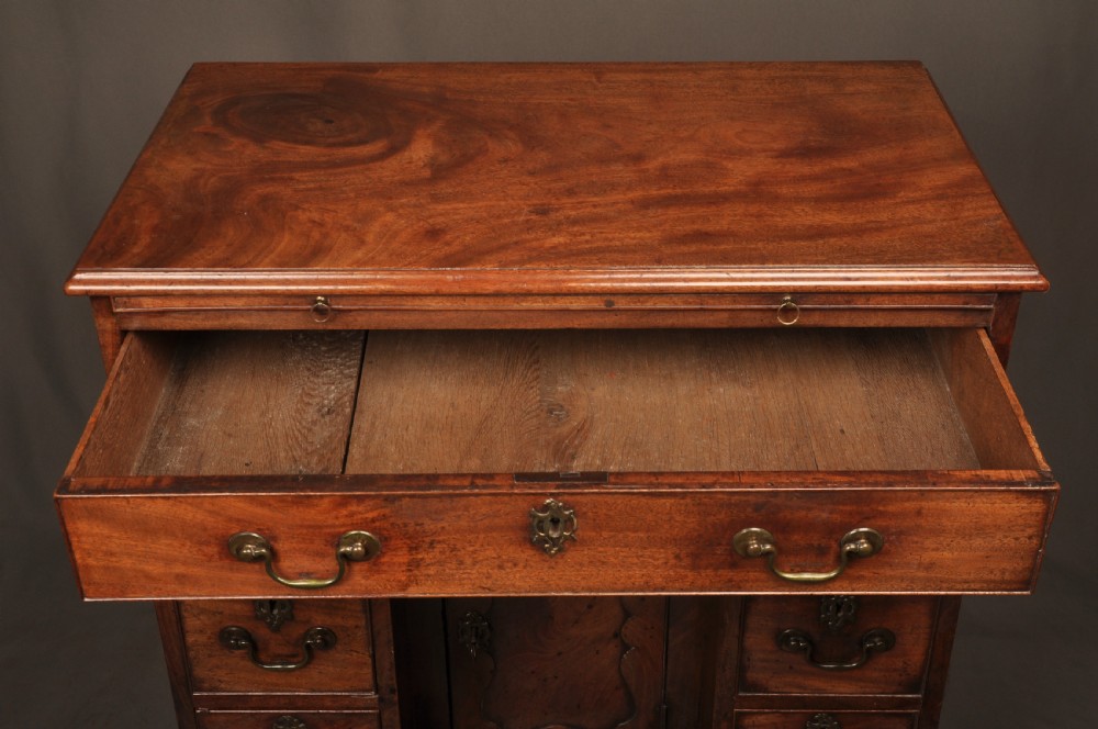 An 18th-century mahogany kneehole desk featuring a long upper drawer, six smaller side drawers, a central recessed cupboard, and bracket feet. View VIII
