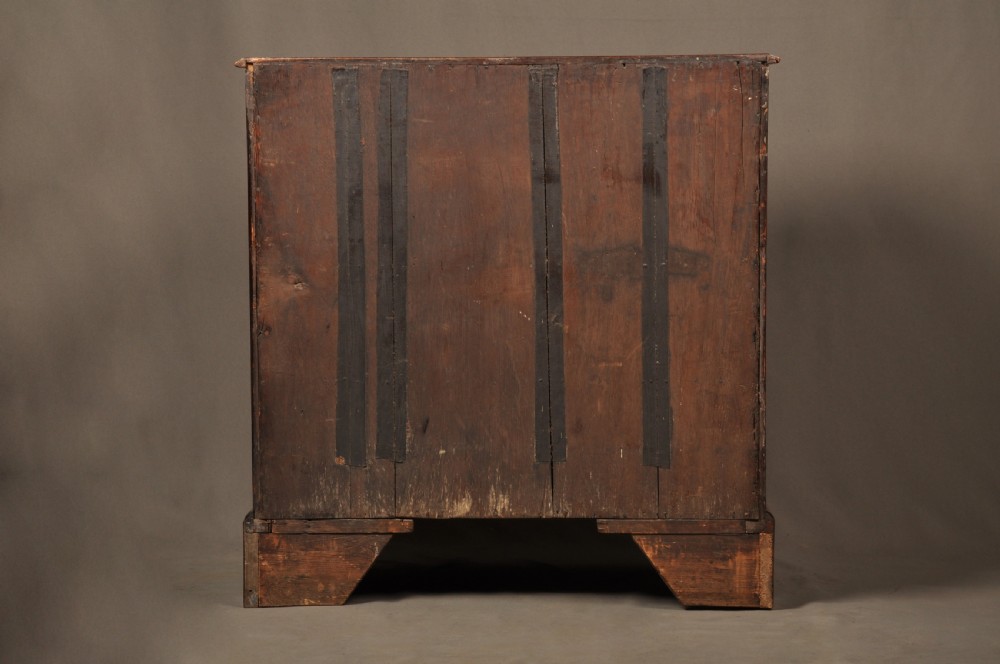 An early George II burr walnut chest of drawers featuring four graduated drawers with brass handles, a brushing slide, featherbanding, and bracket feet. View XI