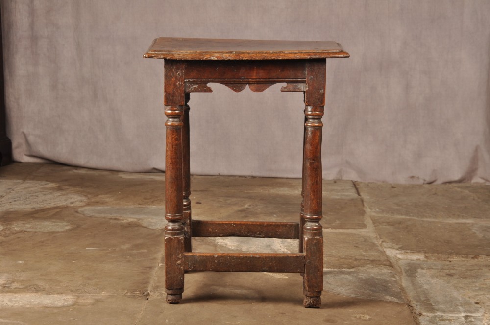 A mid-17th-century solid oak joint stool featuring turned legs, a rectangular top, and lower perimeter stretchers. View II