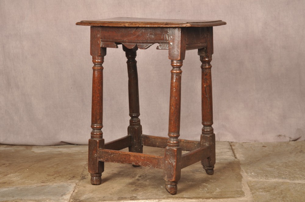 A mid-17th-century solid oak joint stool featuring turned legs, a rectangular top, and lower perimeter stretchers. View III