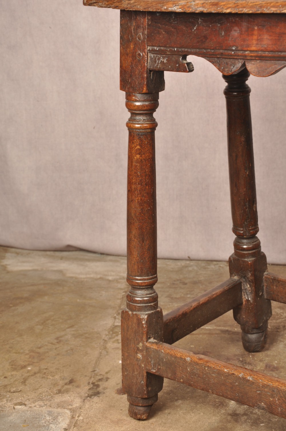 A mid-17th-century solid oak joint stool featuring turned legs, a rectangular top, and lower perimeter stretchers. View VIII