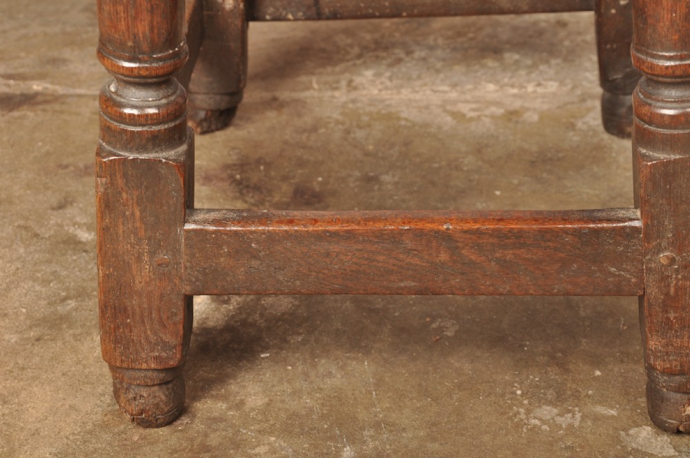 A mid-17th-century solid oak joint stool featuring turned legs, a rectangular top, and lower perimeter stretchers. View XI