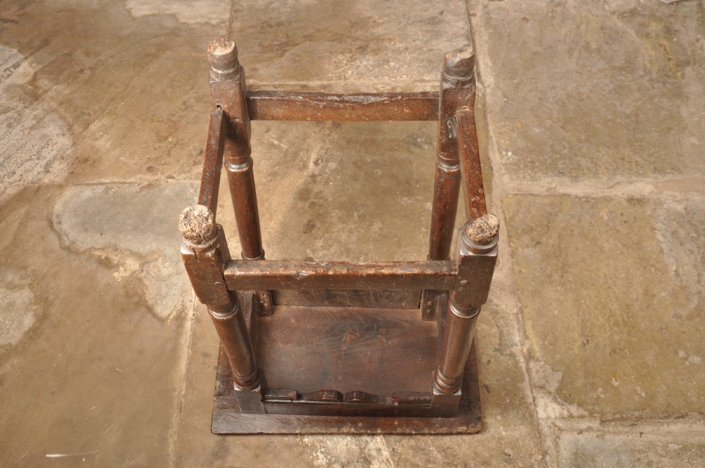 A mid-17th-century solid oak joint stool featuring turned legs, a rectangular top, and lower perimeter stretchers. View XII
