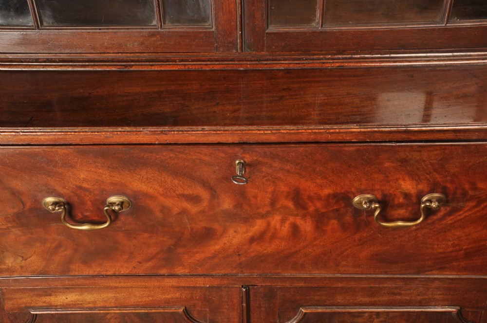 An 18th-century mahogany secretaire bookcase featuring a dentil cornice, astragal-glazed upper cabinet doors, a drop-front writing drawer with brass handles, and a two-door lower cupboard resting on bracket feet. View IV
