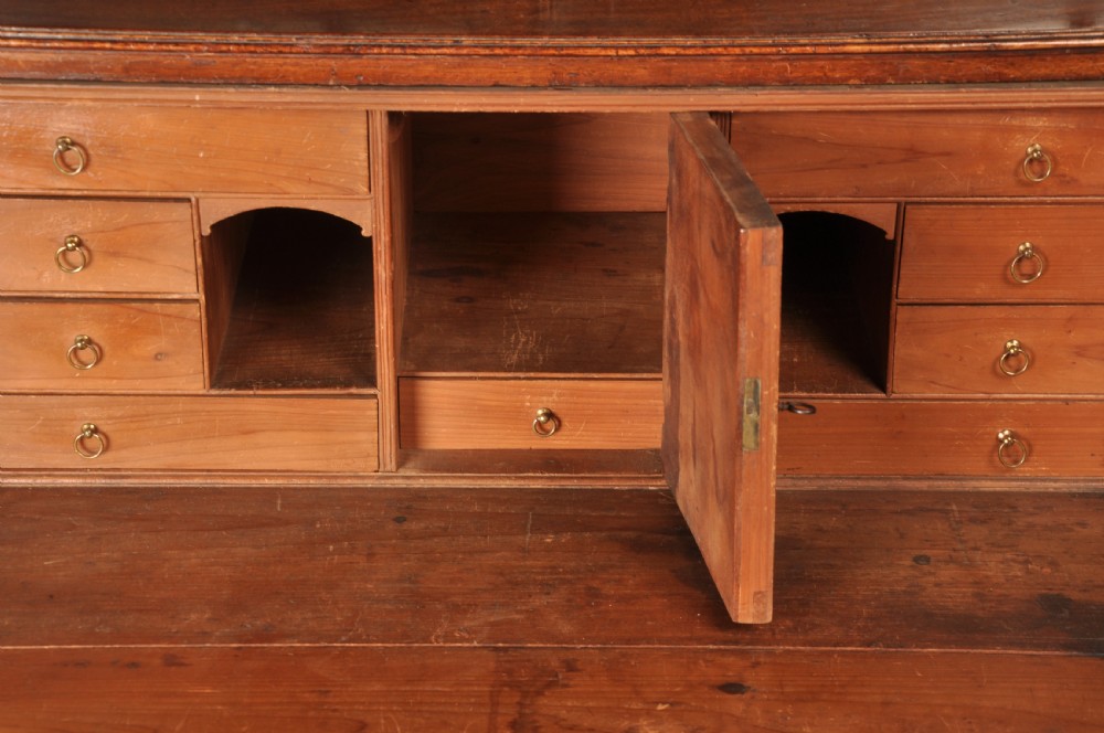 An 18th-century mahogany secretaire bookcase featuring a dentil cornice, astragal-glazed upper cabinet doors, a drop-front writing drawer with brass handles, and a two-door lower cupboard resting on bracket feet. View XIII