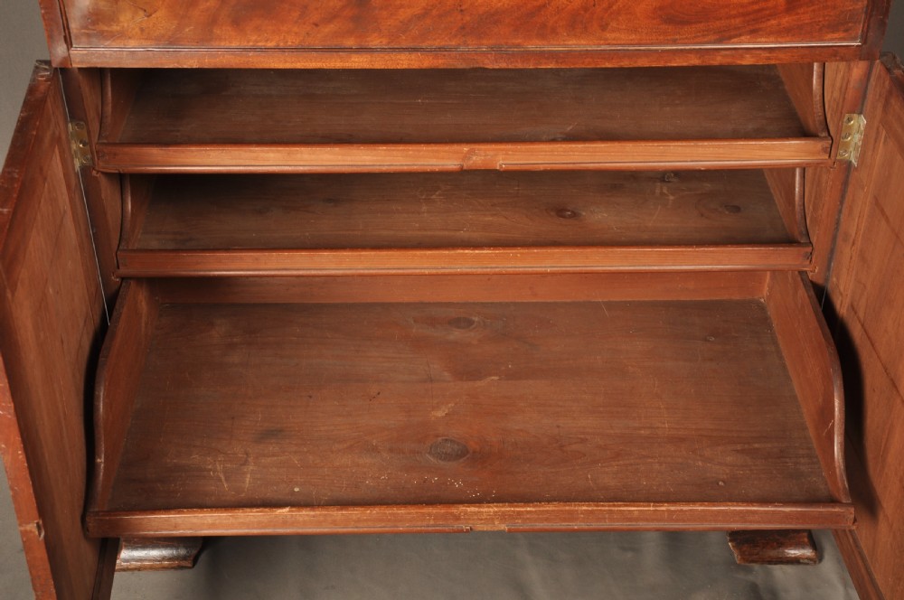 An 18th-century mahogany secretaire bookcase featuring a dentil cornice, astragal-glazed upper cabinet doors, a drop-front writing drawer with brass handles, and a two-door lower cupboard resting on bracket feet. View XVI