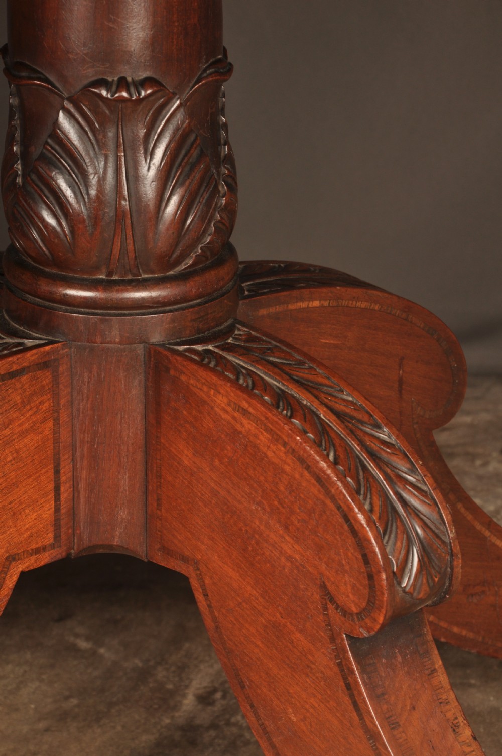 A Regency mahogany breakfast table featuring a rounded rectangular top, a turned central pedestal with acanthus carving, and four splayed legs with brass paw feet. View IV