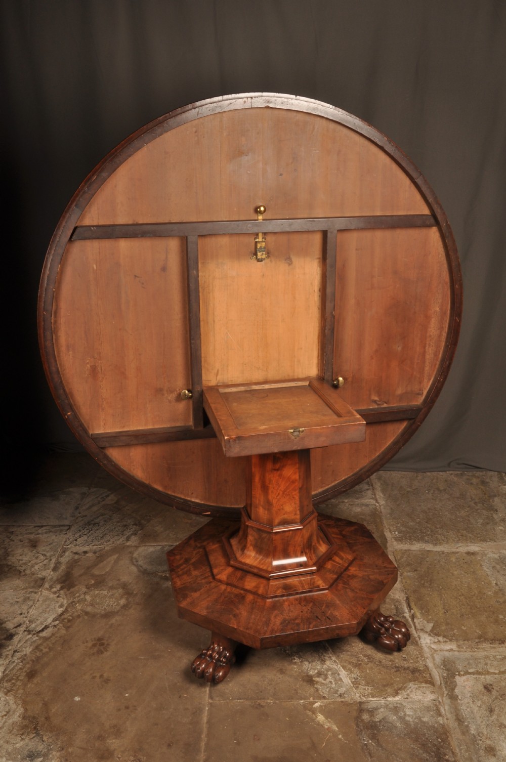 A circular Regency mahogany breakfast table featuring flame mahogany radial veneers, a faceted pedestal, and carved lion paw feet. View VIII