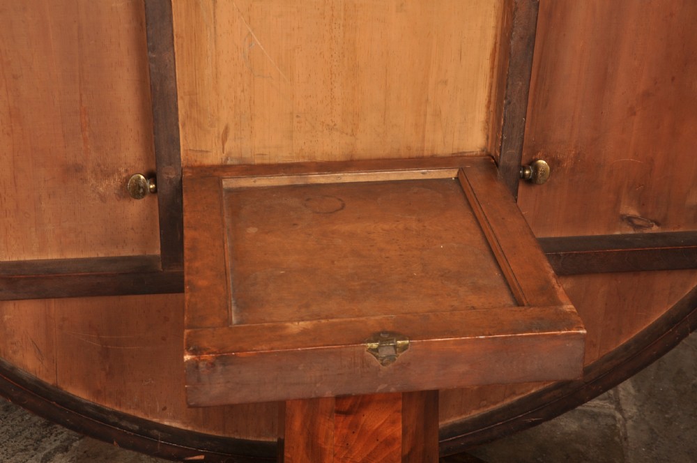 A circular Regency mahogany breakfast table featuring flame mahogany radial veneers, a faceted pedestal, and carved lion paw feet. View IX