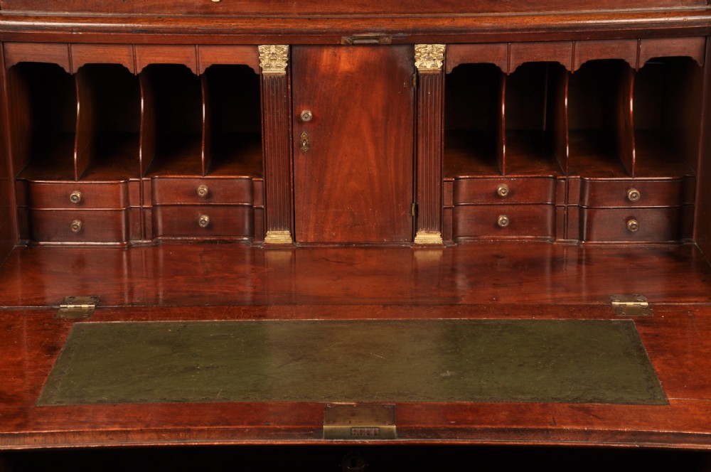 An 18th-century mahogany bureau cabinet featuring an architectural pediment top, two panelled upper doors, a slant-front writing desk, and lower drawers on bracket feet. View IV