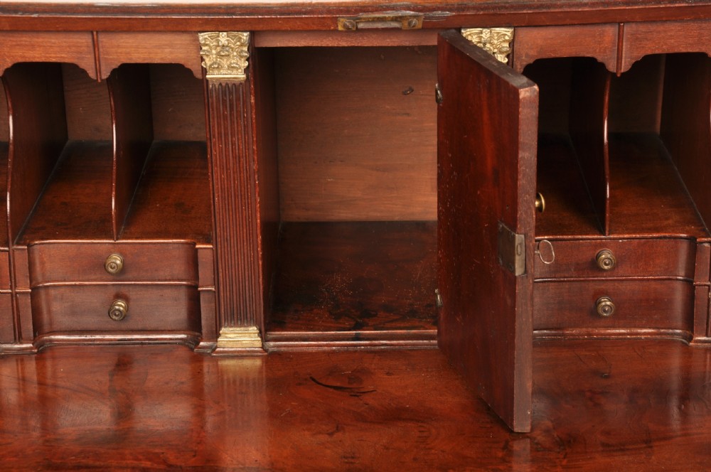 An 18th-century mahogany bureau cabinet featuring an architectural pediment top, two panelled upper doors, a slant-front writing desk, and lower drawers on bracket feet. View VI