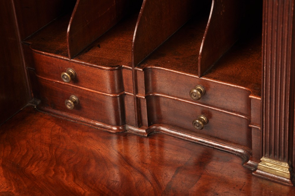An 18th-century mahogany bureau cabinet featuring an architectural pediment top, two panelled upper doors, a slant-front writing desk, and lower drawers on bracket feet. View VII