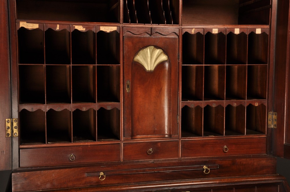 An 18th-century mahogany bureau cabinet featuring an architectural pediment top, two panelled upper doors, a slant-front writing desk, and lower drawers on bracket feet. View XI