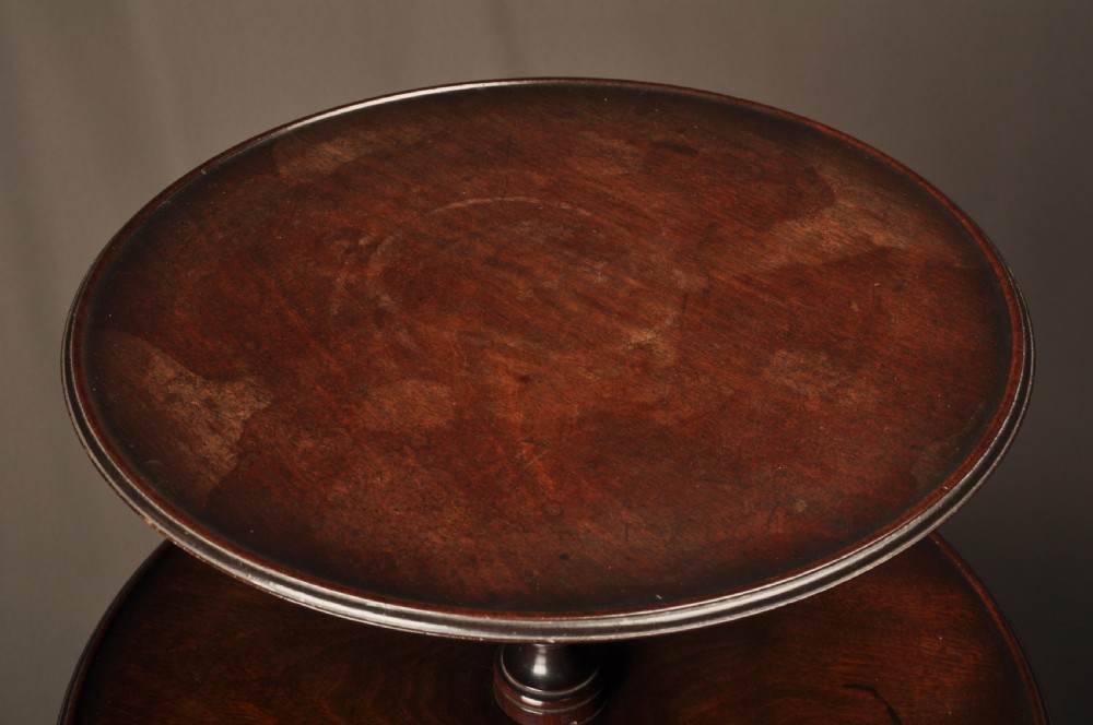 An 18th-century mahogany three-tiered dumb waiter featuring graduated dished trays, a turned central column, and tripod cabriole legs. View VII